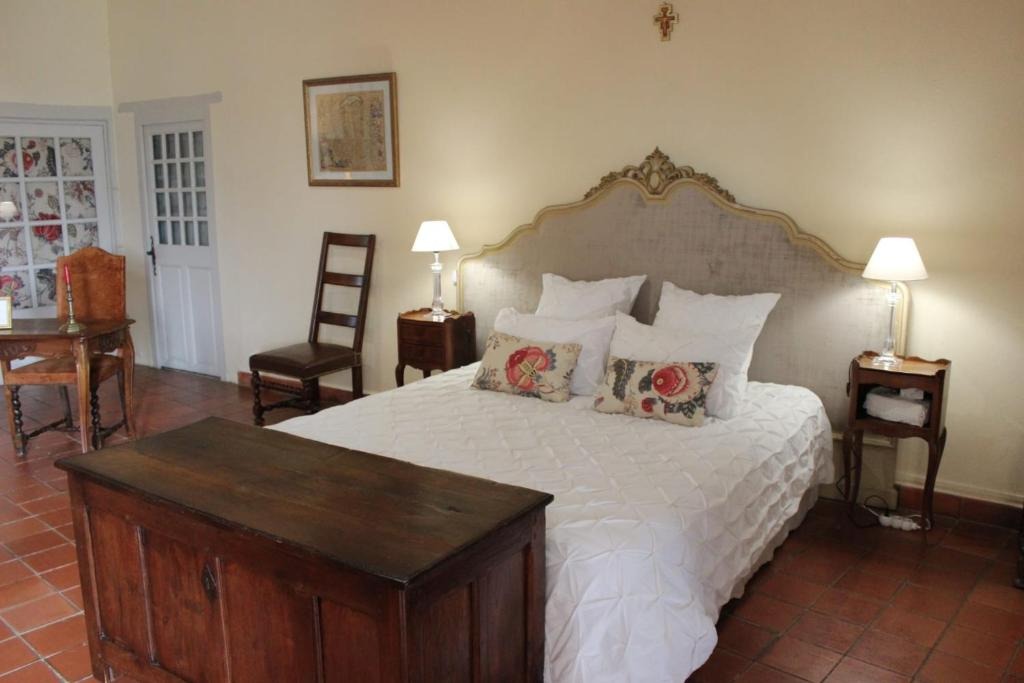 Chambre de la suite avec lit ancien et poutres apparentes